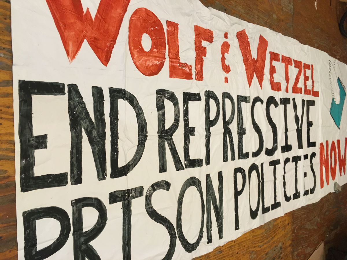 Banner demanding Wolf and Wetzel repeal prison policies